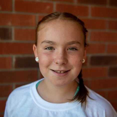 Young girl wearing Franco-Ontarien acrylic earrings
