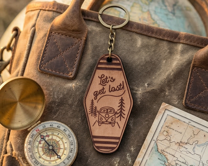 Leather keychain with 'Let's get lost!' text and vintage map on a textured surface