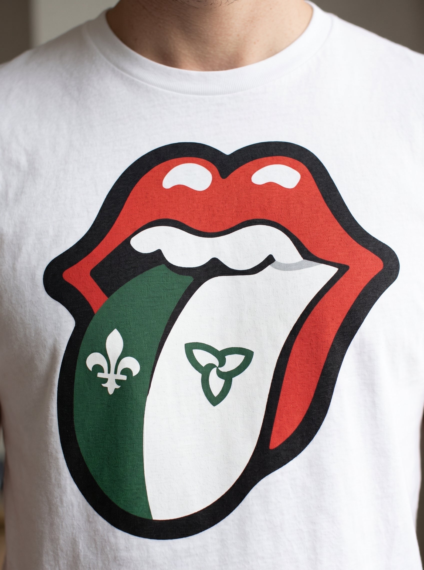 A close-up of a white crewneck t-shirt featuring a large graphic print of the Rolling Stones tongue logo, with the franco ontario flag on the tongue.