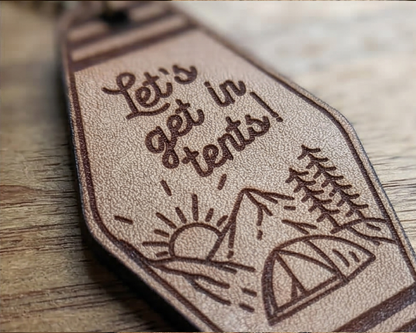 leather kechain with 'Let's get in tents!' engraving on a wooden surface