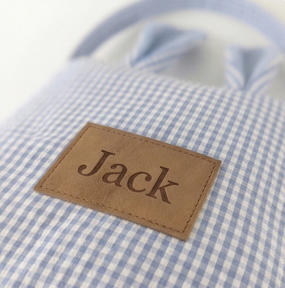 Close-up of a blue and white checkered shirt with a brown label reading 'Jack'.