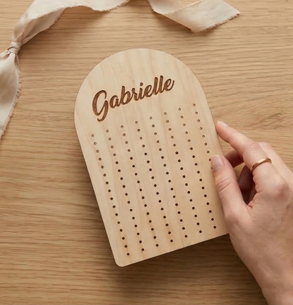 Wooden earring holderwith 'Gabrielle' engraved on a wooden surface