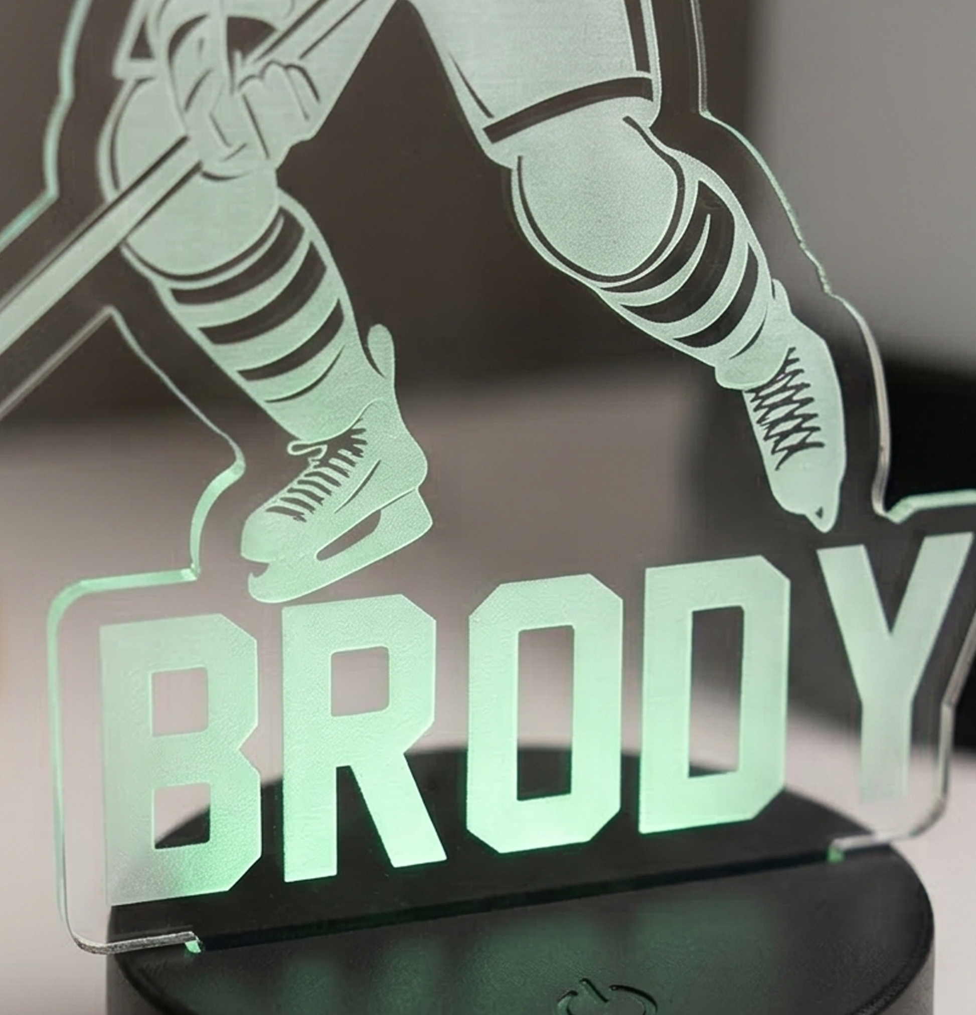 Glowing acrylic plaque with hockey player silhouette and 'Brody' text on a dark background
