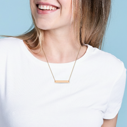 Person wearing a gold necklace against a light blue background