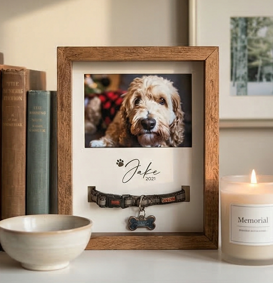 Framed photo of a dog with a collar and 'Memorial' candle on a shelf.