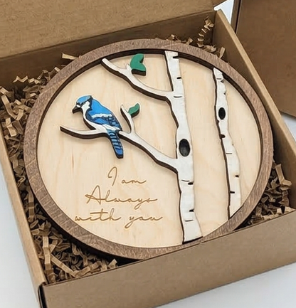 Wooden plaque with a blue jay design and 'I am Always with You' text, placed in a box.
