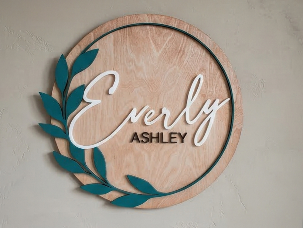 Wooden wall decor with 'Everly Ashley' text on a plain background