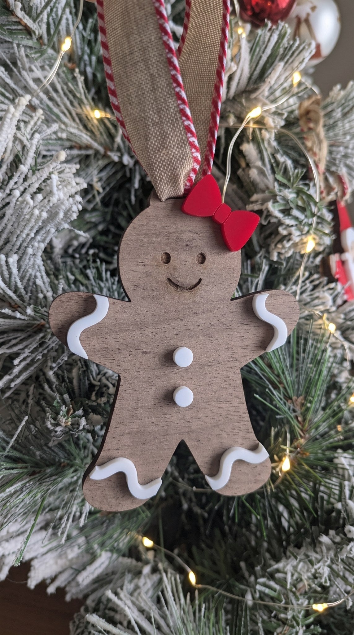 Layered walnut and acrylic gingerbread girl ornament with red bow